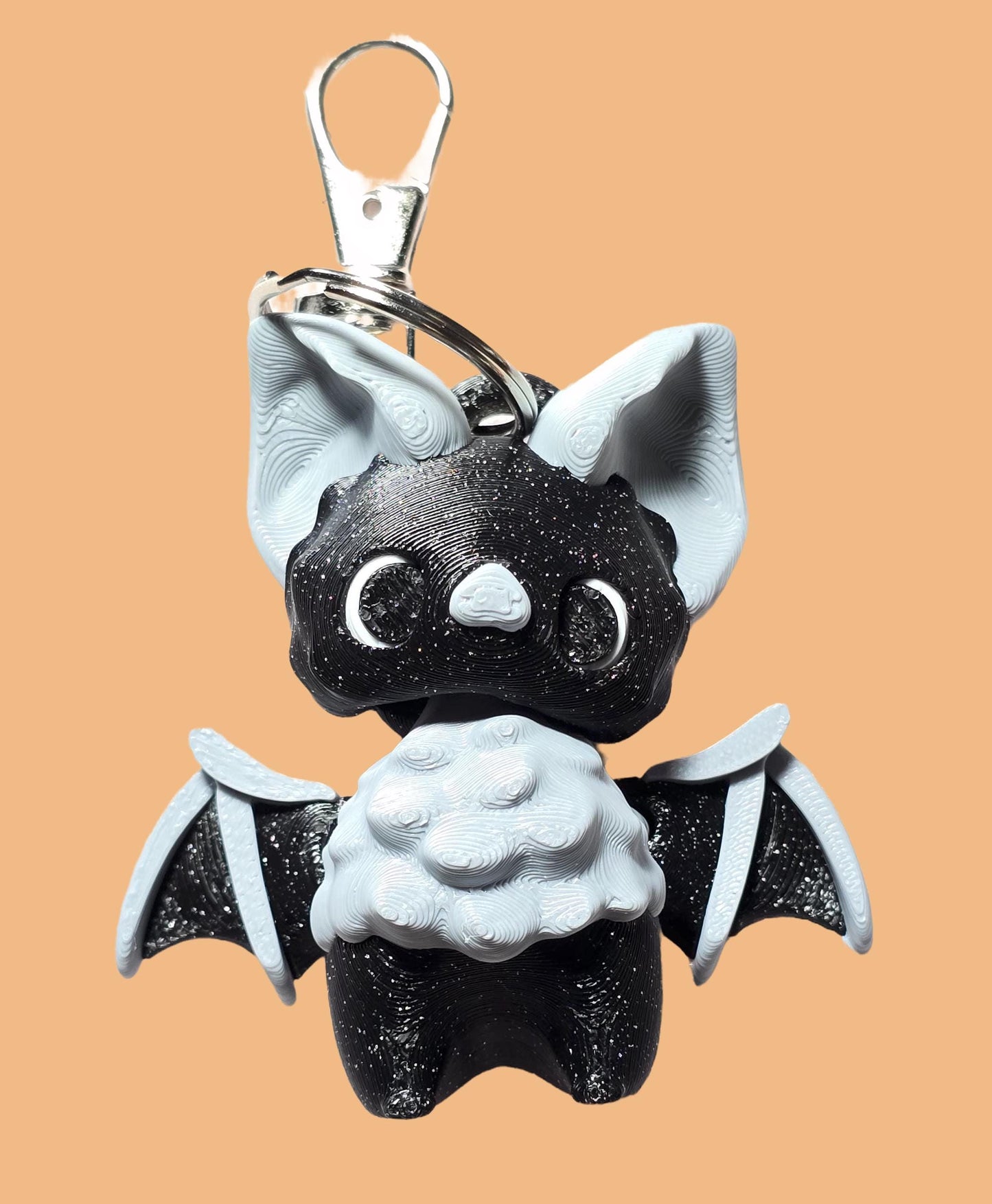 a black and white bat shaped key chain